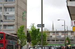 three green bikes emerge from the wall of Roehampton Library